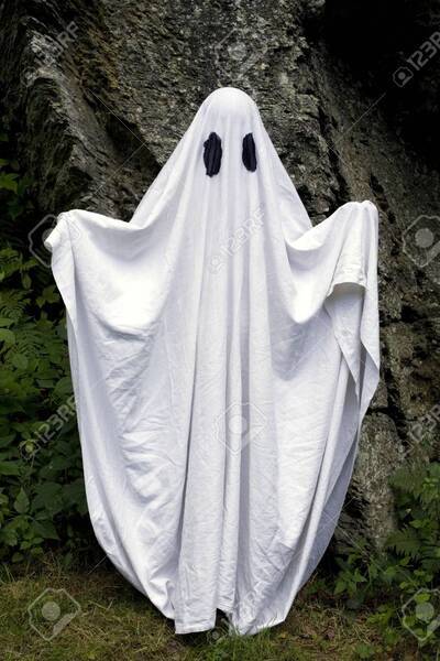 10-a-spooky-white-ghost-covered-by-a-sheet-with-slits-over-the-eyes-standing-in-front-of-a-rock-.jpg