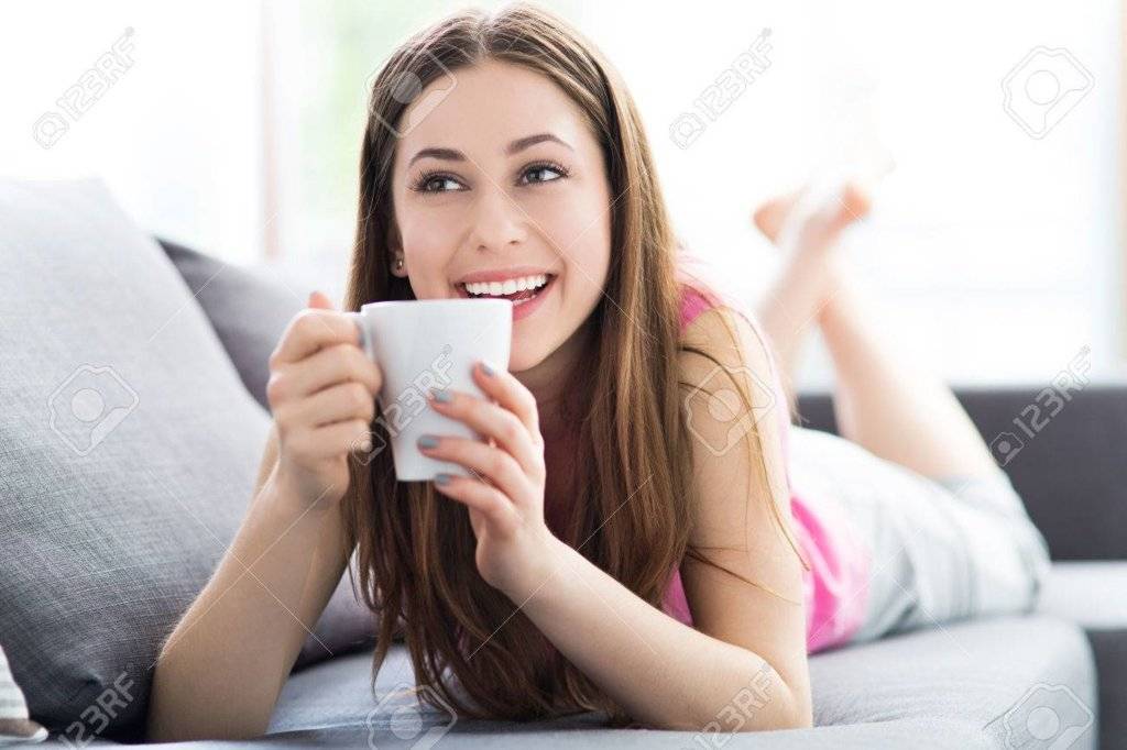 41960124-Woman-drinking-coffee-on-sofa-Stock-Photo.jpg