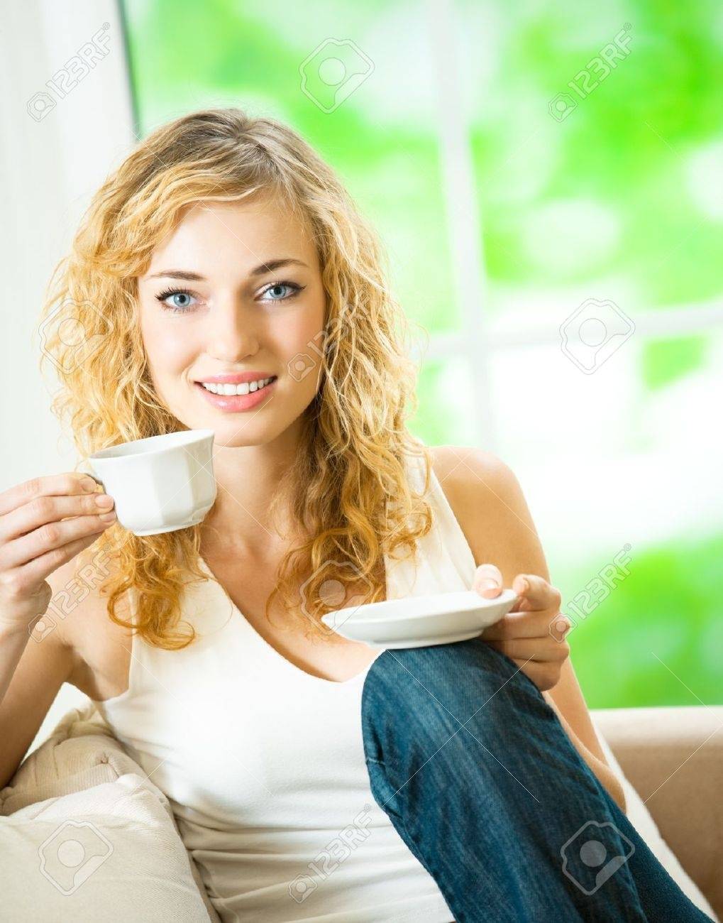 8629853-Young-happy-smiling-woman-drinking-coffee-at-home-Stock-Photo.jpg