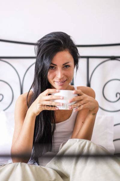 focused_173786394-stock-photo-woman-drinking-coffee-bed.jpg